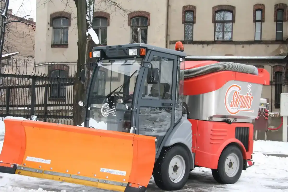 Красная машина Skrubis со снежным отвалом, готовая к уборке снега зимой